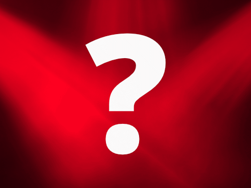A large white question mark underneath red stage lighting
